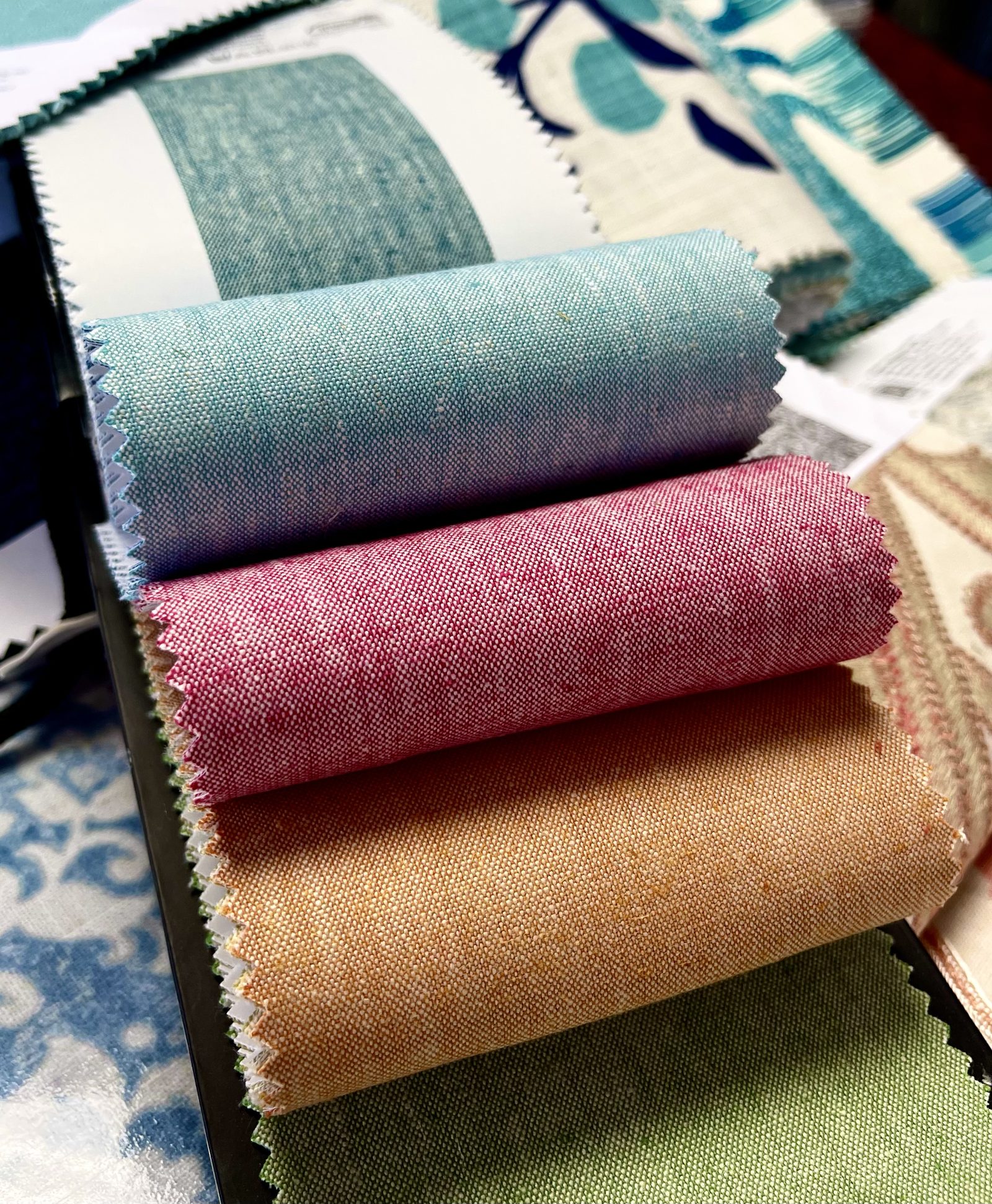 Rolls of upholstery fabric in blue, pink, orange and green